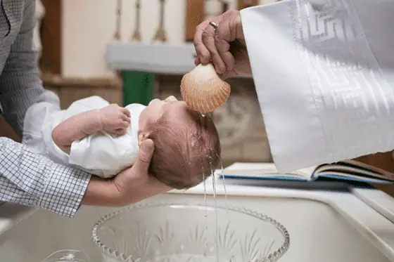 The act of Baptism being performed on a child in the Church