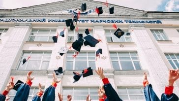A group of graduate students throwing up their academic hats
