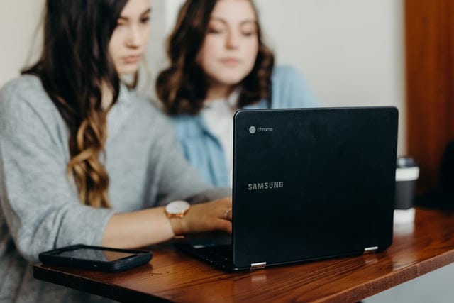 Two women working on a laptop
